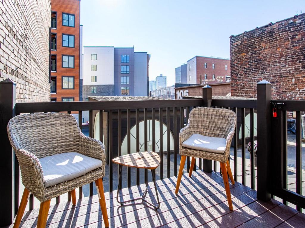 诺克斯维尔Elegant Old City Loft - Downtown的阳台配有2把椅子和1张桌子