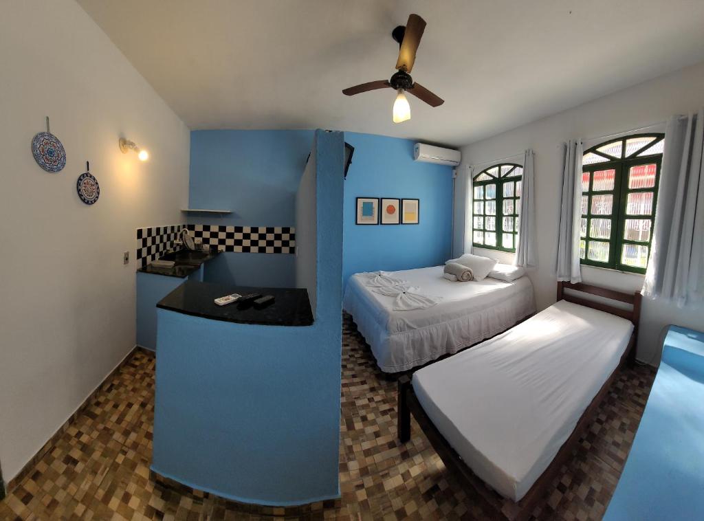阿拉亚尔达茹达Pousada Simbiose的一间卧室设有两张床和蓝色的墙壁