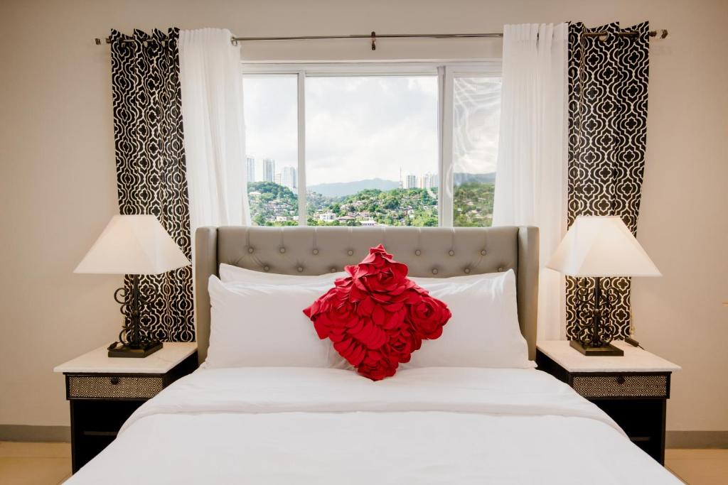 宿务Sta Barbara Residence Hotel的一间卧室,床上有红花