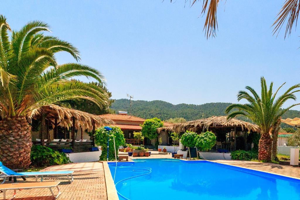 沃尔沃罗Kissos Apartments的一个带游泳池和棕榈树的度假村