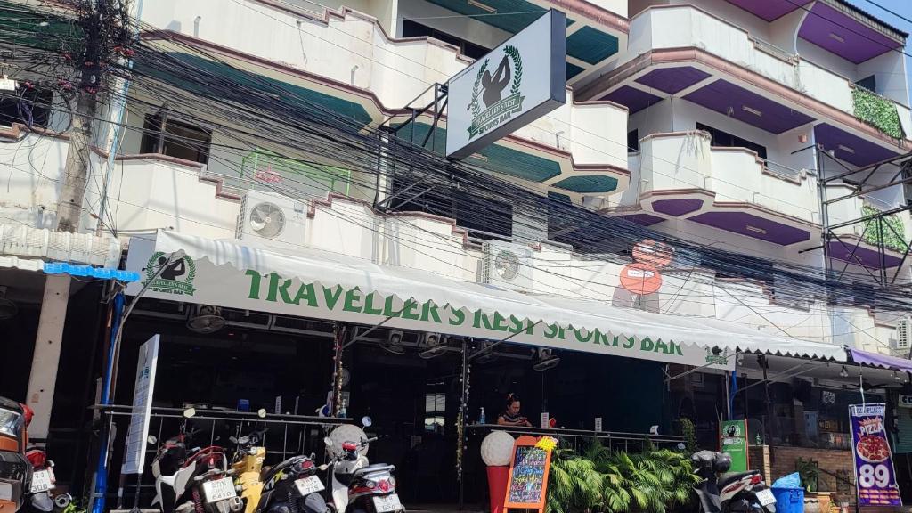 芭堤雅市中心旅行者休息运动酒吧酒店的带有读过tayaelaksenis icyasy的标志的建筑