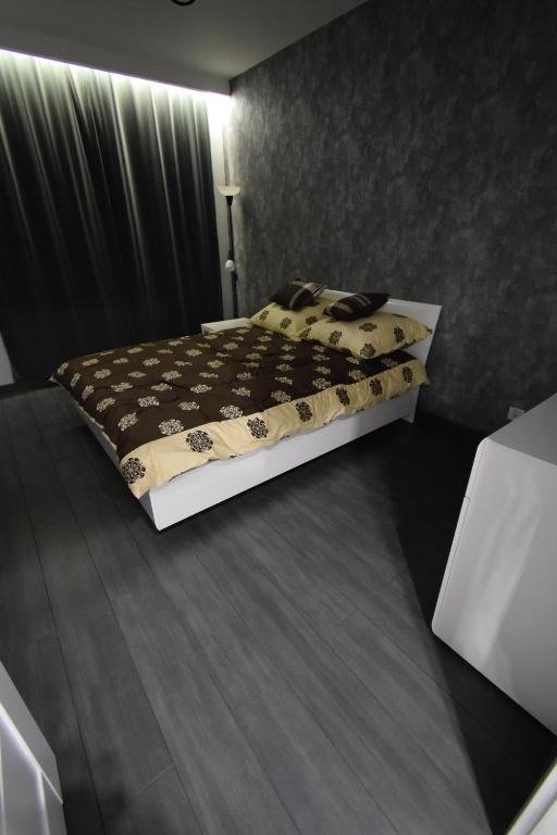 乔左维尔考普尔斯基Londyńska 9的一间卧室配有一张带黑色和棕色床罩的床。