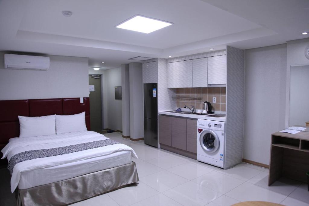 乌兰巴托J酒店的一间卧室配有一张床和一台洗衣机