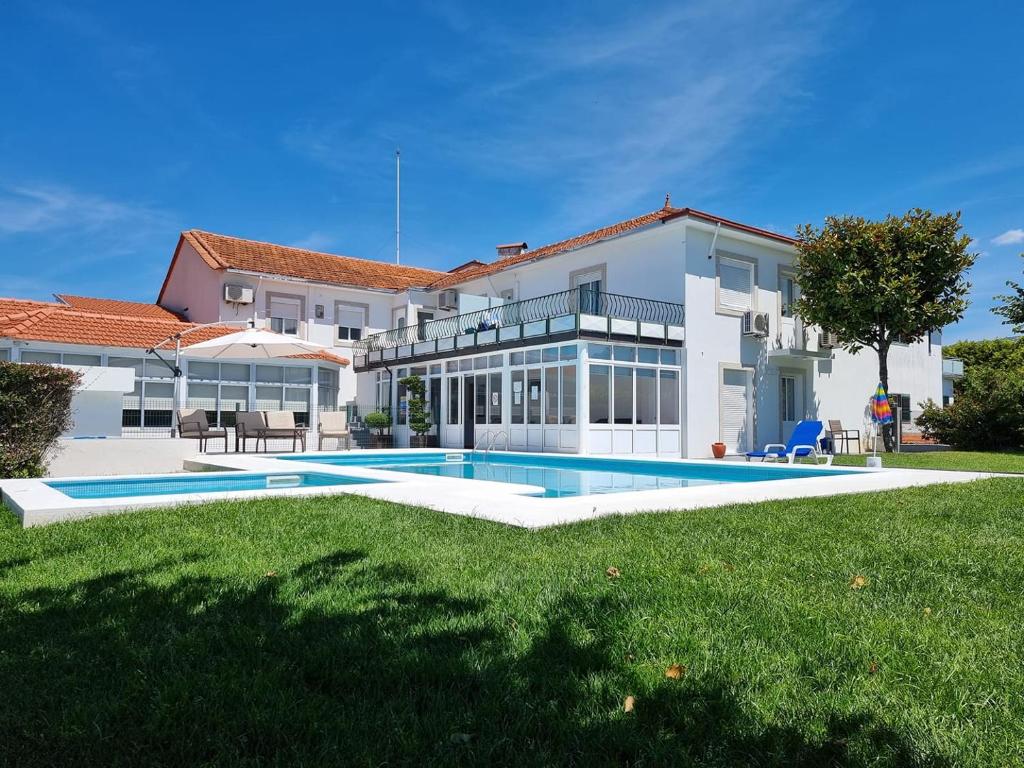 瓦莱迪坎布拉太阳能达斯拉兰热拉斯酒店的一座大房子,在庭院里设有一个游泳池