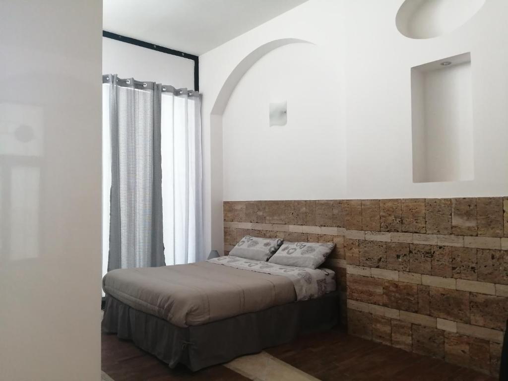 LizzanelloLoft的一间卧室设有一张床和砖墙