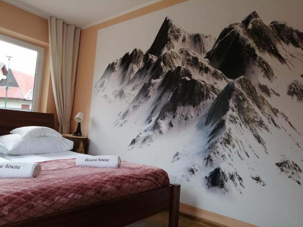 扎科帕内Apartament Giencyno Koncina Zakopane的卧室的墙上挂有山壁画