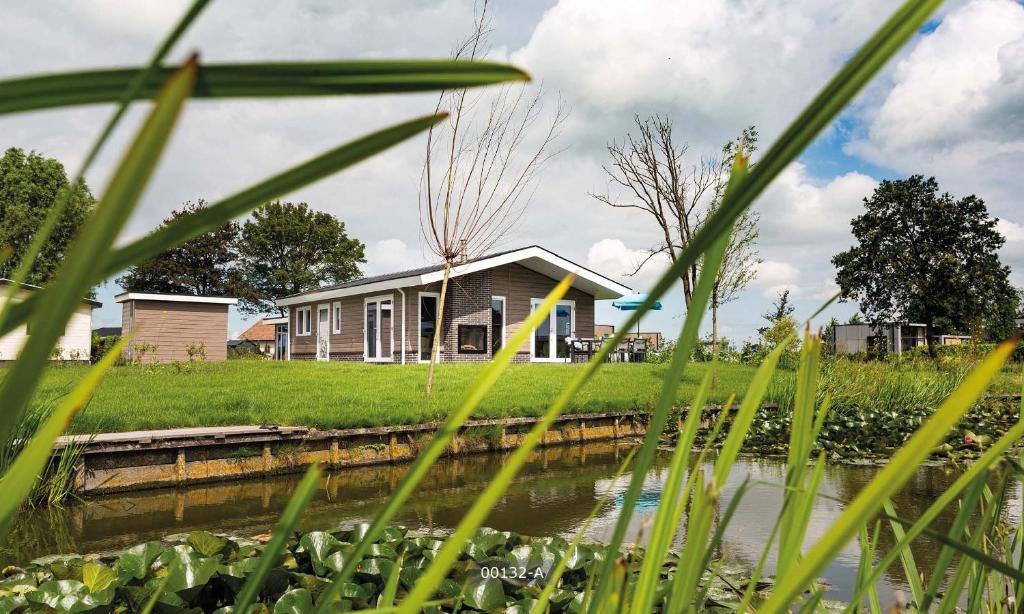 BerkhoutTopParken – Park Westerkogge的河岸上高草的房子