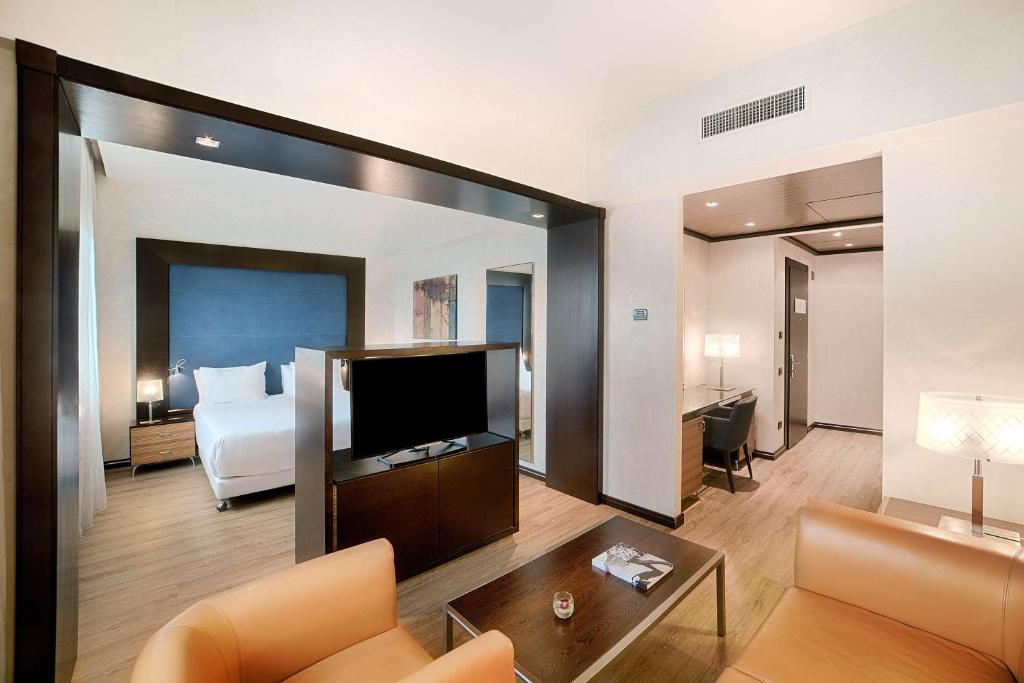 锡耶纳NH锡耶纳酒店的酒店客房设有一张床和一面大镜子