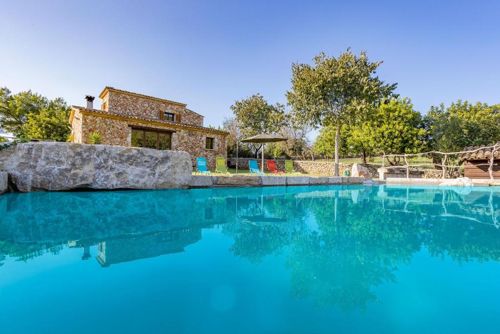 印加Villa Coric的蓝色的海水游泳池,后面有房子