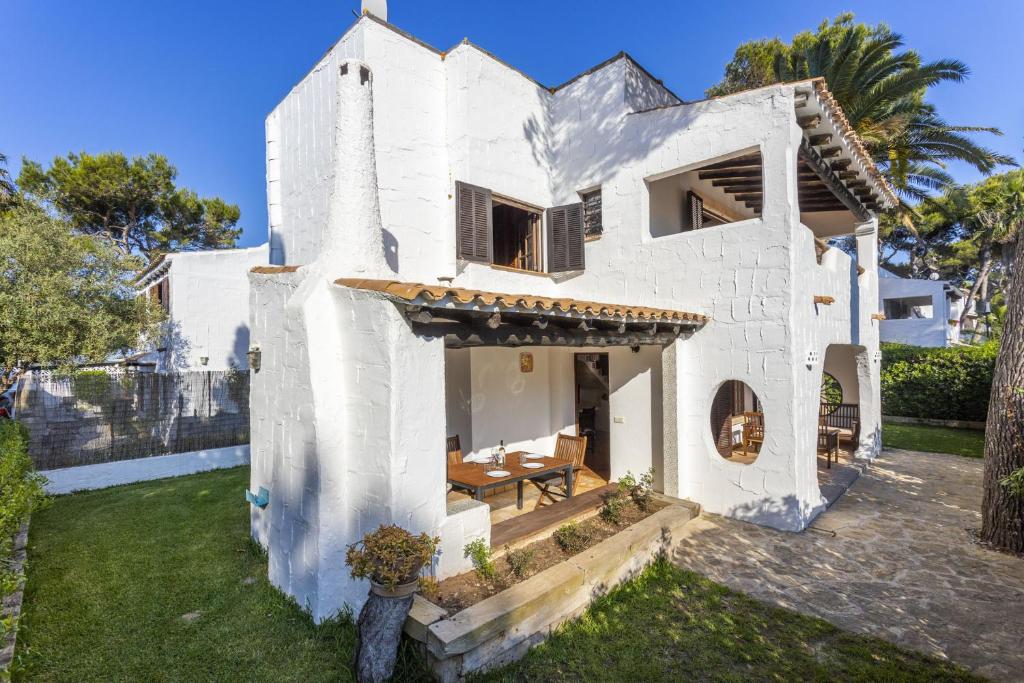 穆罗海滩Casa Ibicenca Sagitario 454的院子里的白色房子,带桌子