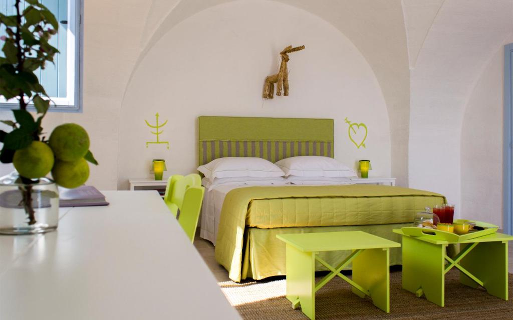 蒙塔尔巴诺马塞里亚科尔特阿布鲁阿斯尼旅馆的一间卧室配有一张带绿色家具和桌子的床。