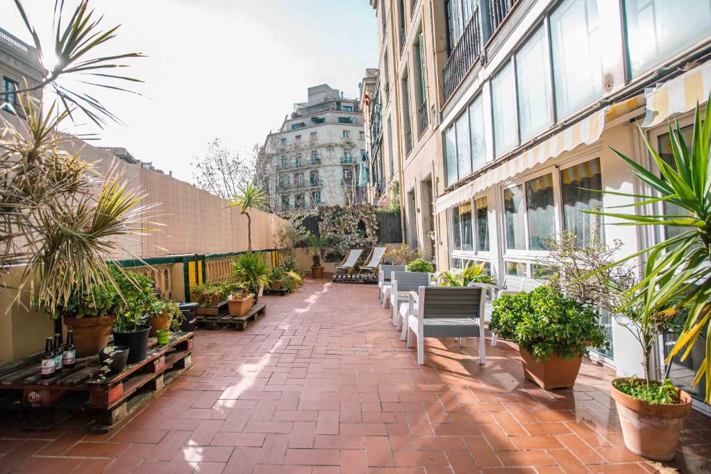 巴塞罗那360 Hostel Borne的一座庭院,里面设有长椅和盆栽植物
