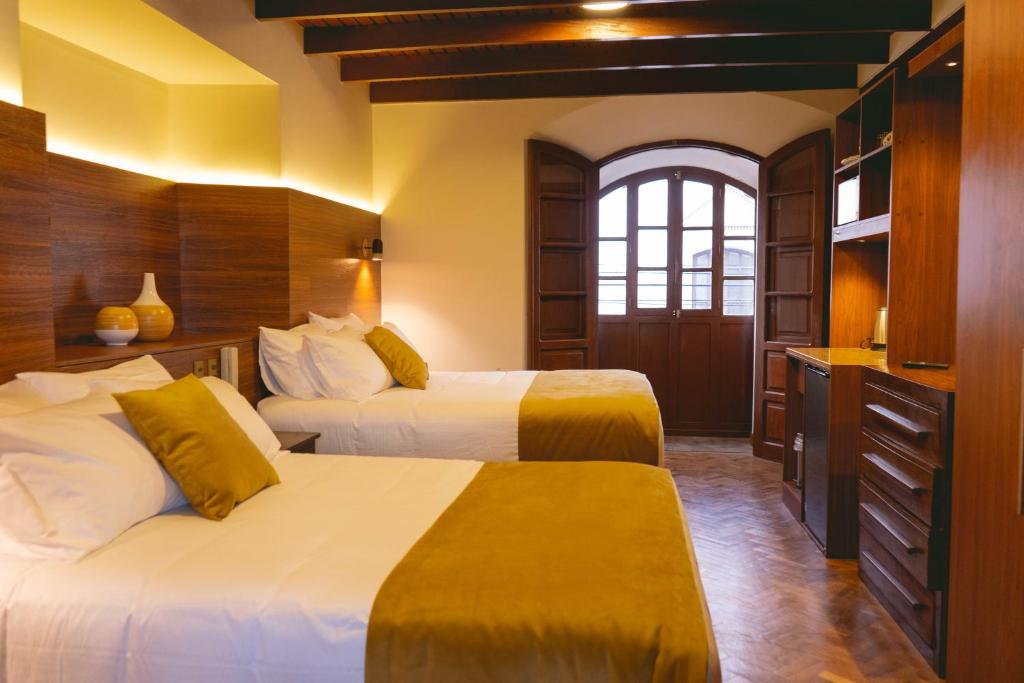 苏克雷San Juan Suites的酒店客房设有两张床和窗户。