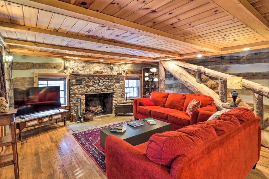 SwissRustic Mars Hill Cabin 20 Miles to Asheville!的客厅配有2张红色沙发和1台电视