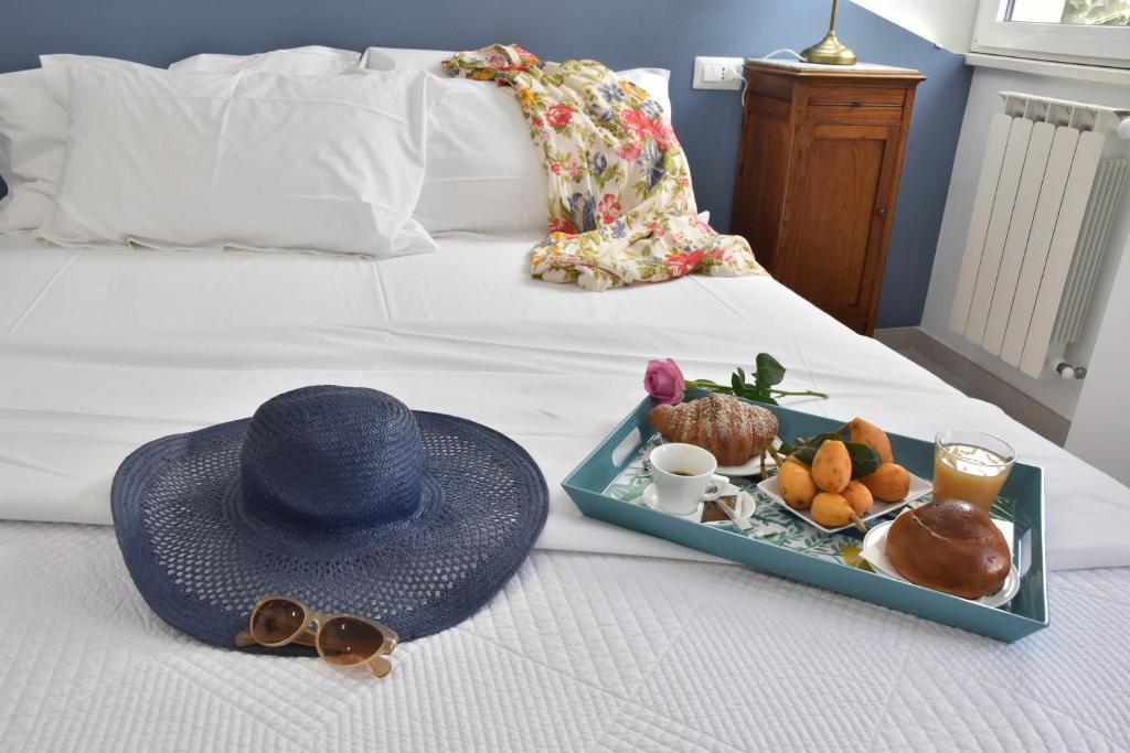 陶尔米纳Taormina Apartments "casa di Anna"的床上的帽子和食物托盘
