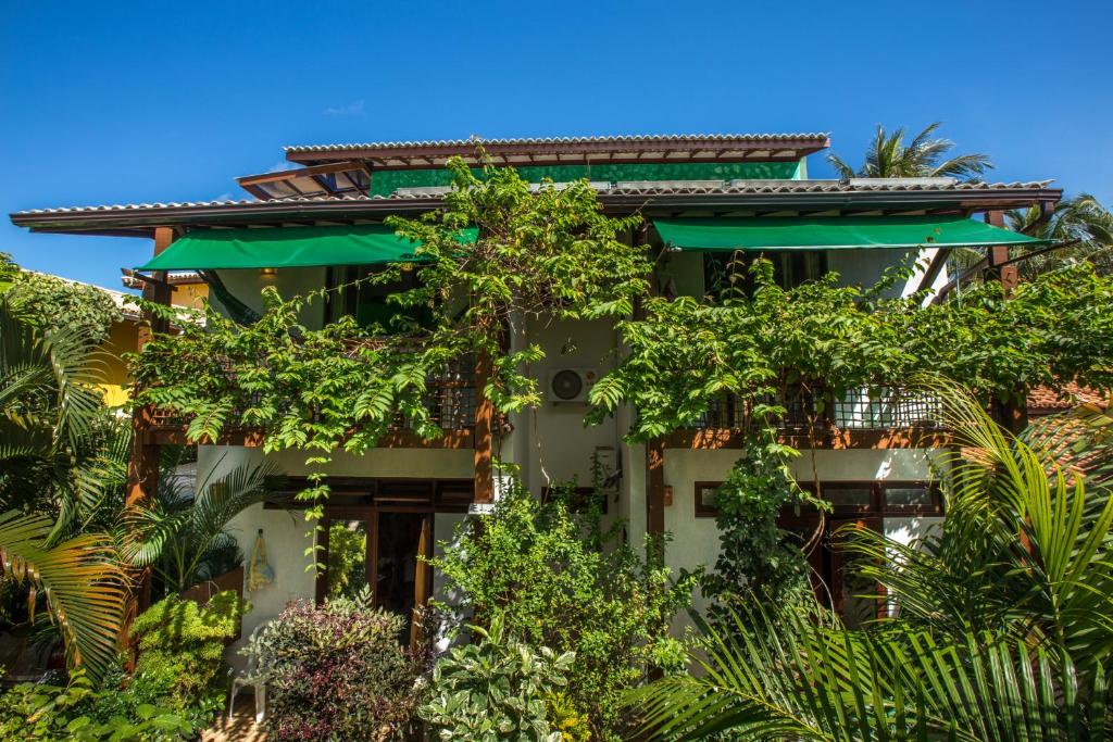 普拉亚多Casa Verde Apart - Aptos e Casa Residencial的前面有树木的建筑