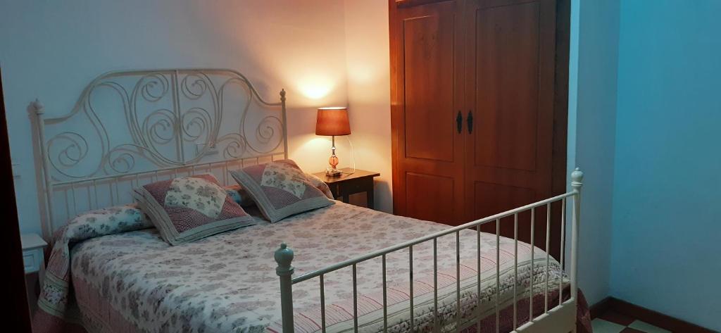 莱图尔Suite La Plaza的一间卧室配有一张床和一张桌子上的台灯
