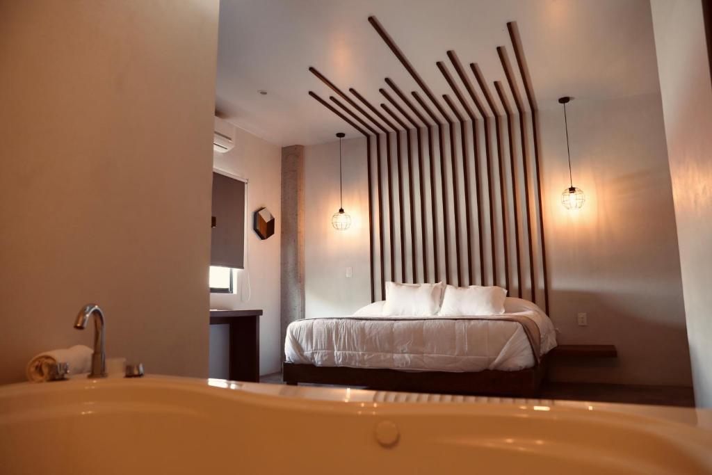 赫雷斯加西亚萨利纳斯Hotel Express Jerez的卧室配有1张床、浴缸和镜子
