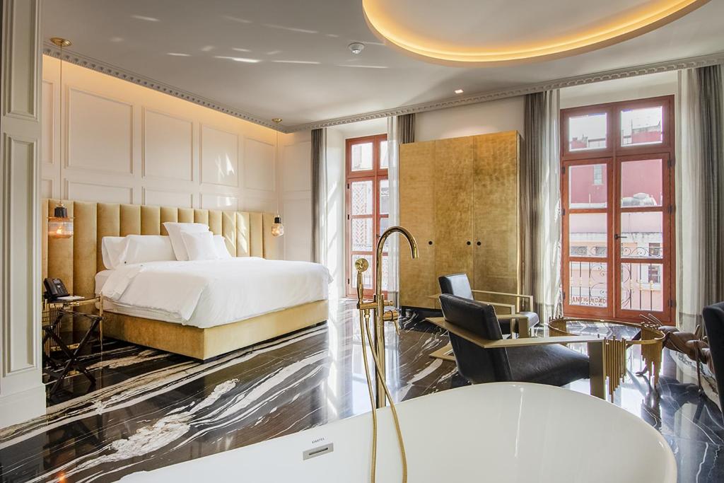 普埃布拉L Hotel Perla Boutique的配有一张床和一张书桌的酒店客房