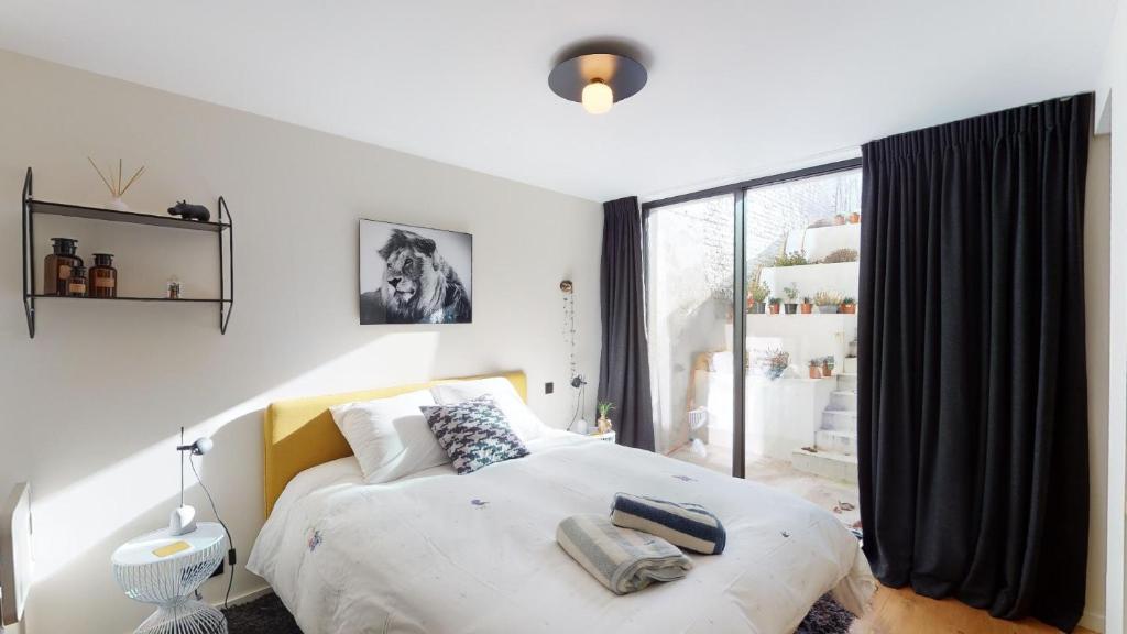 布鲁塞尔Suite lumineuse à Saint-Gilles的一间卧室设有一张床和一个大窗户