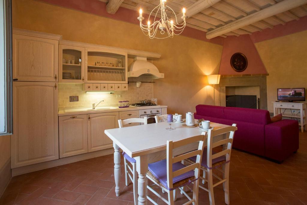 卡斯蒂廖恩菲博基Podere San Pietro Resort的厨房以及带桌子和紫色沙发的用餐室。