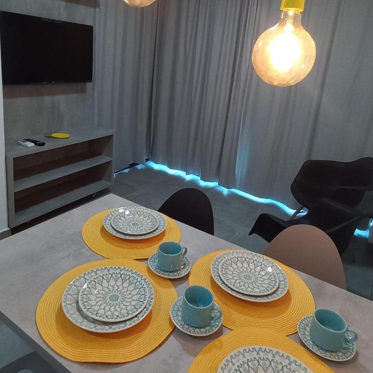 嘎林海斯港Maracaipe condomínio novo, apartamento 103的餐桌,盘子和盘子