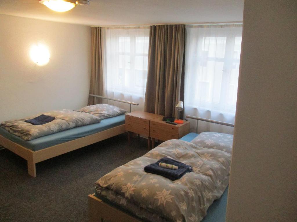 诺德林根Ferienzimmer Monteurzimmer Stadtmitte Nördlingen的酒店客房设有两张床和窗户。