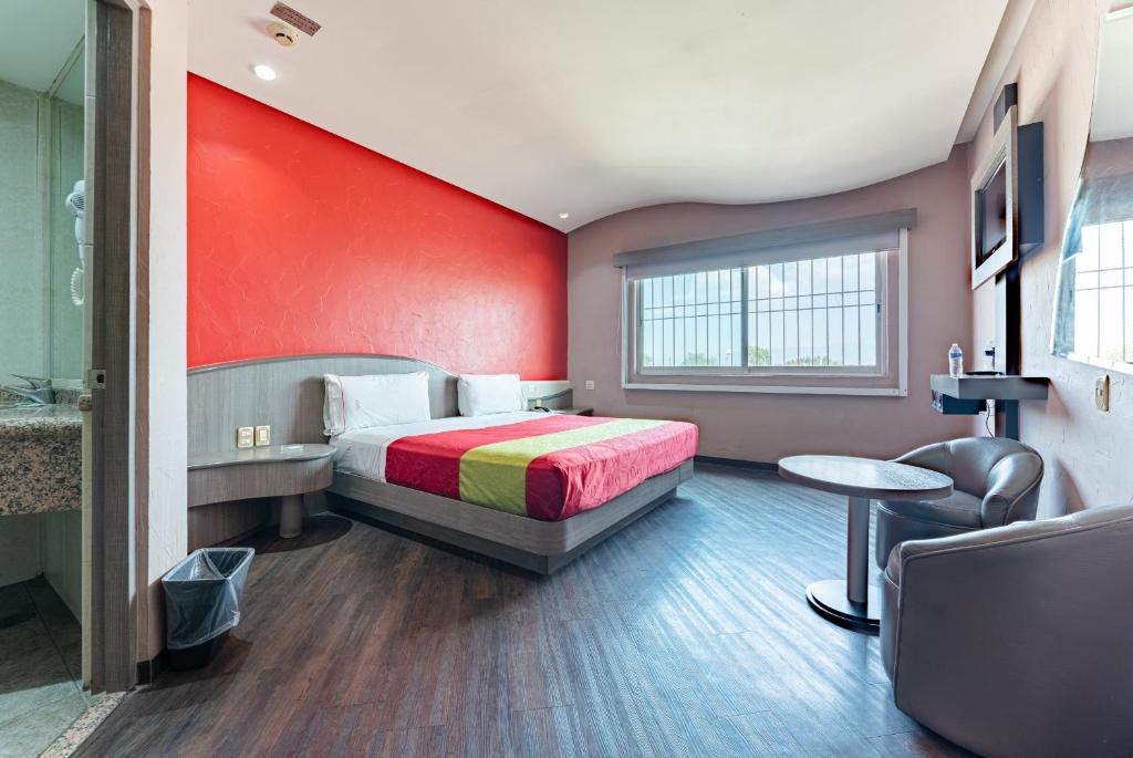 墨西哥城Hotel y Villas Vento的一间卧室设有一张床和红色的墙壁
