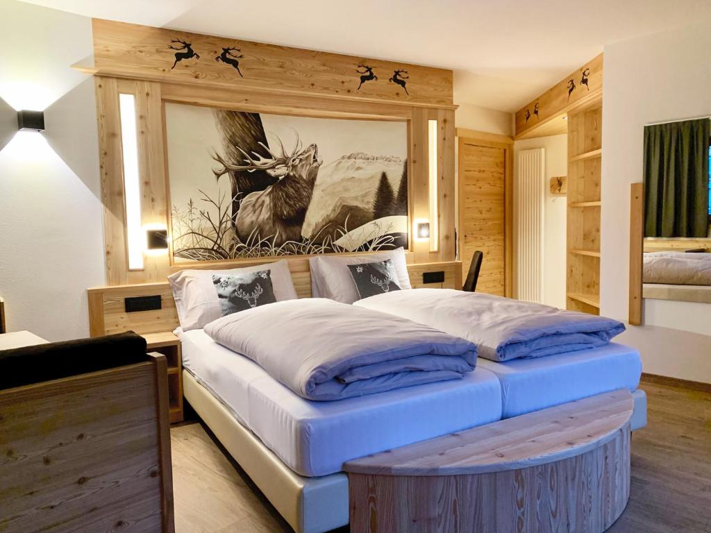 阿拉巴甘智亚娜酒店的卧室配有一张大床,墙上挂有绘画作品