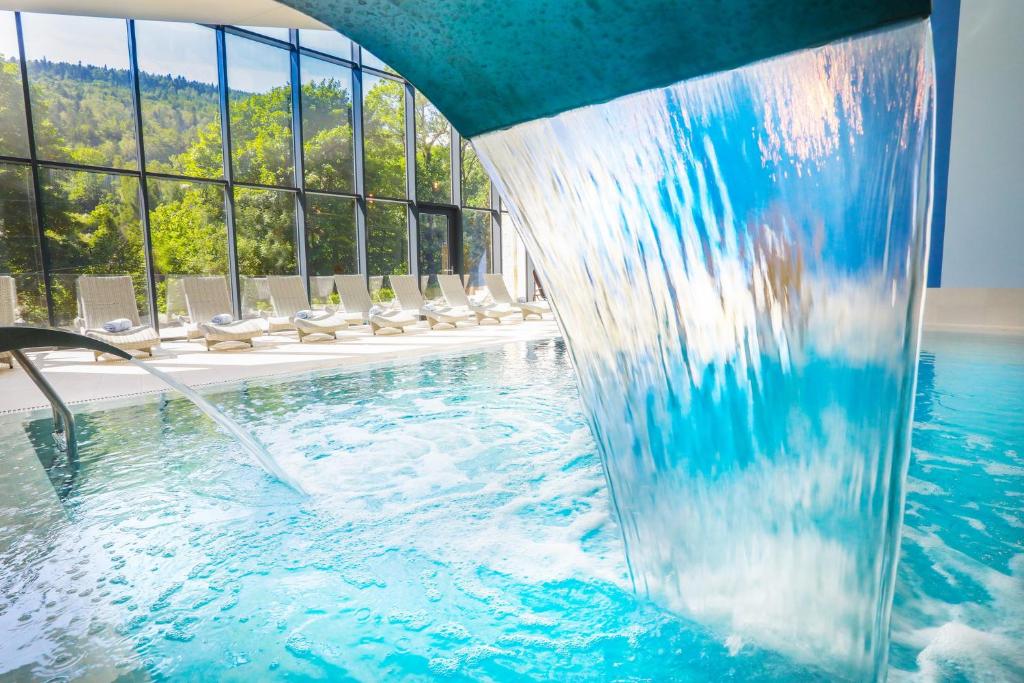 什切尔克Magnus Resort的一座带喷泉的酒店游泳池