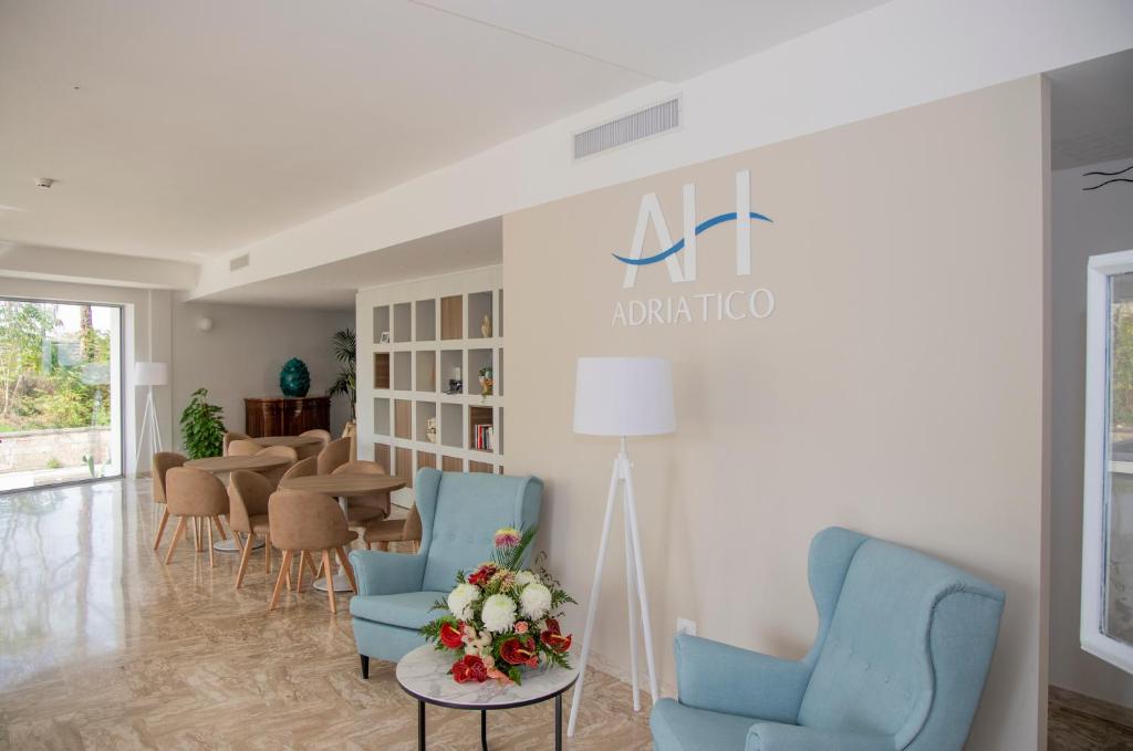 特里卡塞阿迪亚提克酒店的一间设有蓝色椅子和桌子的等候室