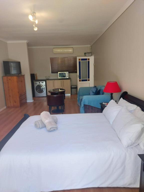 德班维尔Mimosa Self-Catering Studio Durbanville的一间带白色大床的卧室和一间客厅