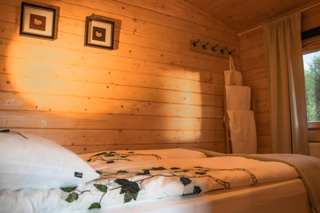 埃基斯蒂尔Kaldá Lyngholt的卧室配有木墙内的一张床