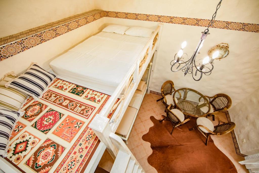 叶夫帕托里亚Guest House Viktoriya的卧室配有一张床和一张桌子及椅子