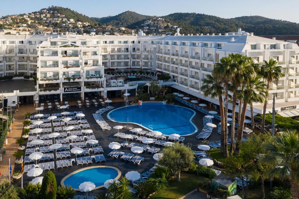 圣苏珊娜AQUA Hotel Aquamarina & Spa的享有带游泳池和遮阳伞的度假村的空中景致