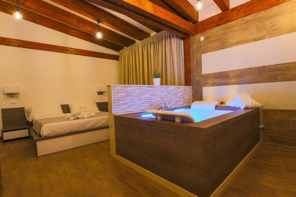 塔瓦娜Il Semaforo Sila Hotel的一间带浴缸的浴室和一张位于客房内的床