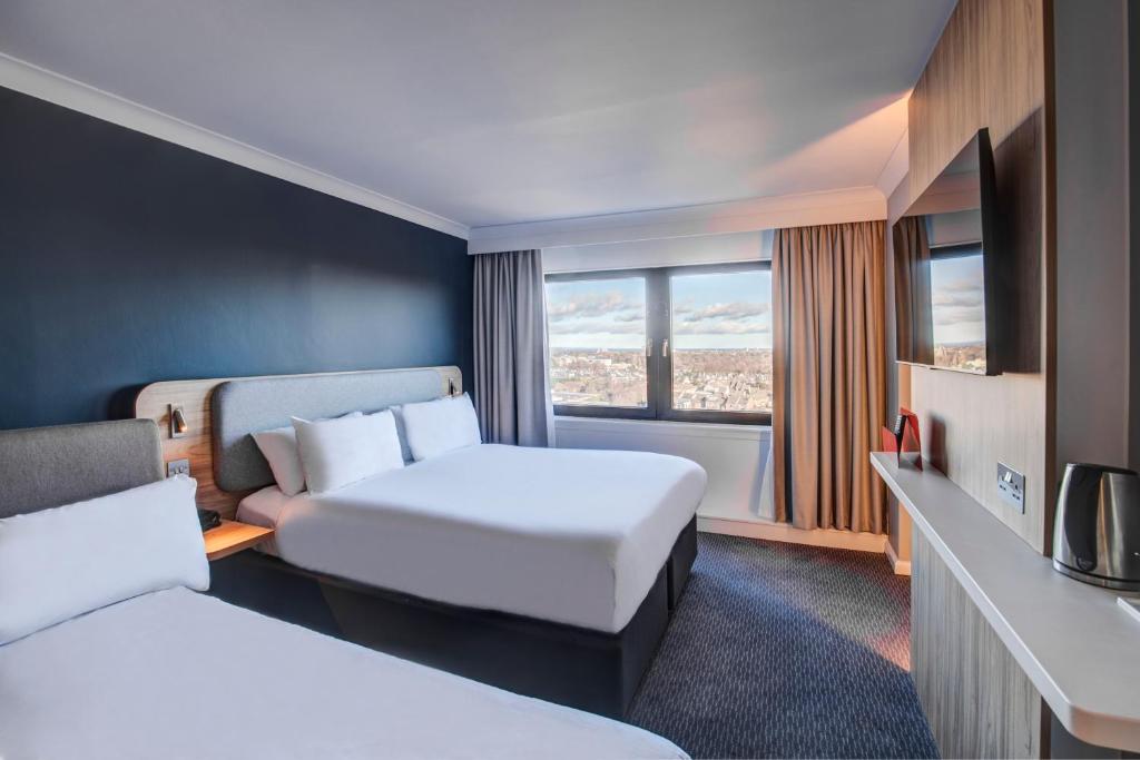 爱丁堡Holiday Inn Express Edinburgh City West, an IHG Hotel的酒店客房设有两张床和窗户。