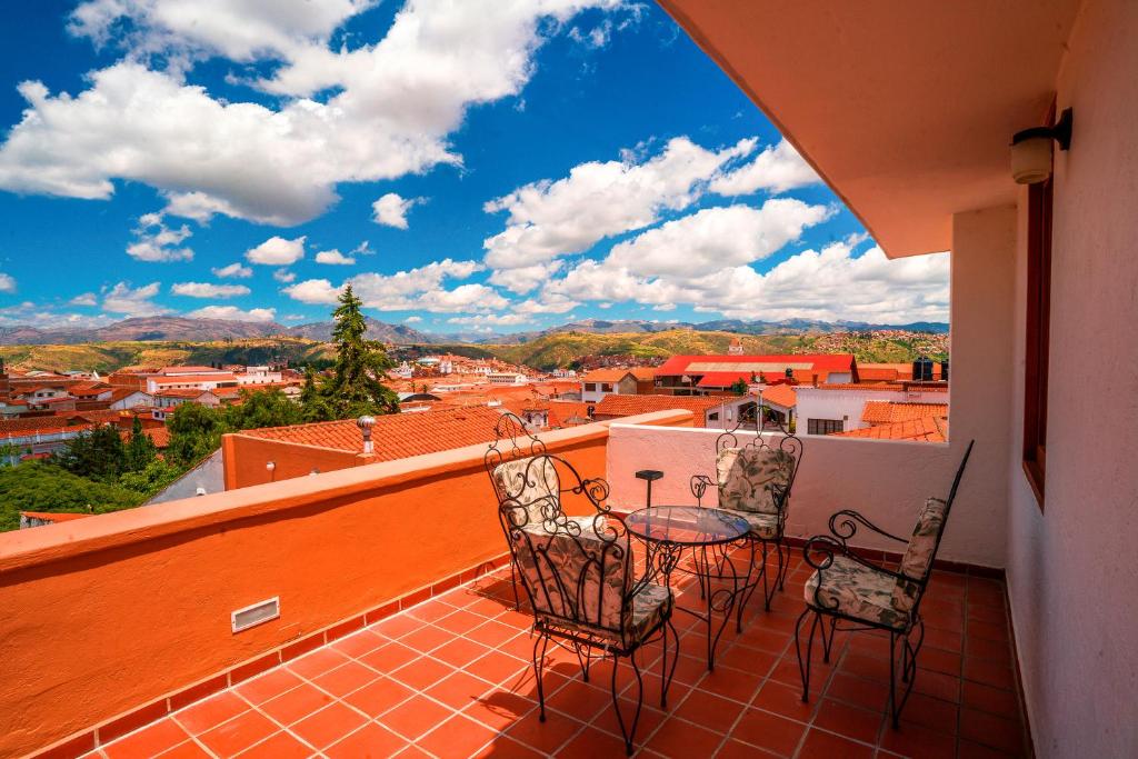 苏克雷安提瓜别墅酒店的阳台配有2把椅子和1张桌子,享有风景。