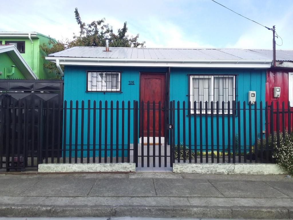 蒙特港Casa Pali的蓝色的房子,有红色的门和栅栏