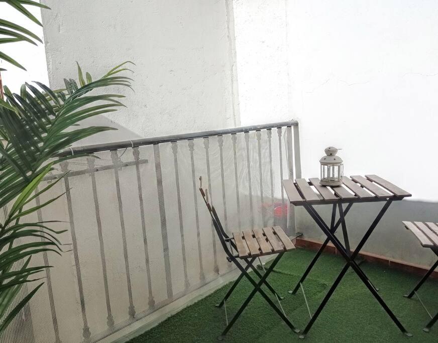 马德里Inhome的阳台配有一张桌子和两把椅子
