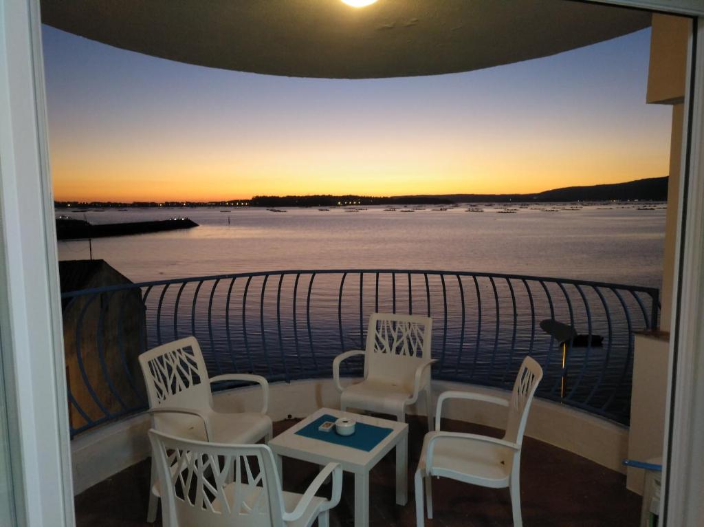 阿罗萨新镇Apartamentos Poniente的阳台配有桌椅,享有日落美景。