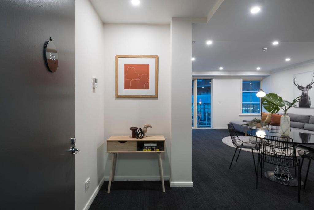 墨尔本Melbourne South Yarra Central Apartment Hotel Official的一间带桌子的客厅和一间餐厅