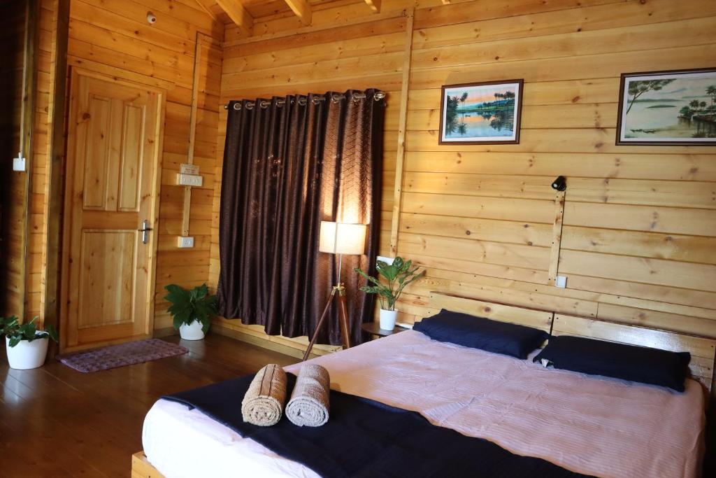 Munroe IslandGreenChromide Homestays的木制客房内的一间卧室,配有一张床