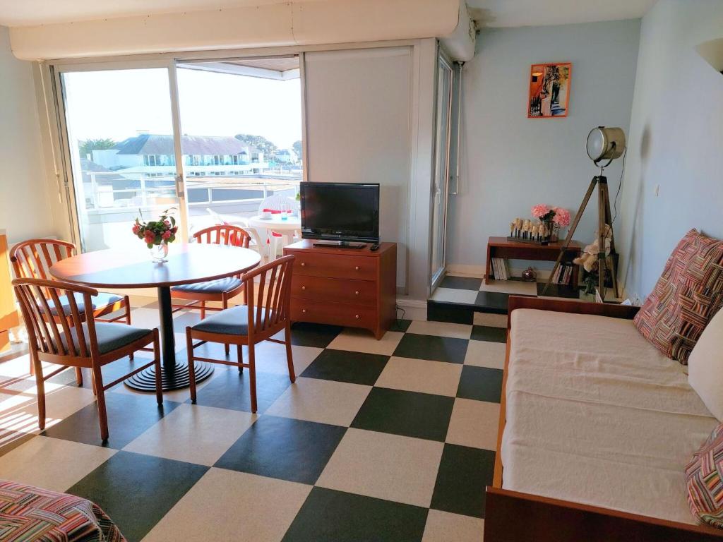 贝诺代Studio with partial sea views in the popular seaside resort of Benodet的客厅配有桌子和沙发