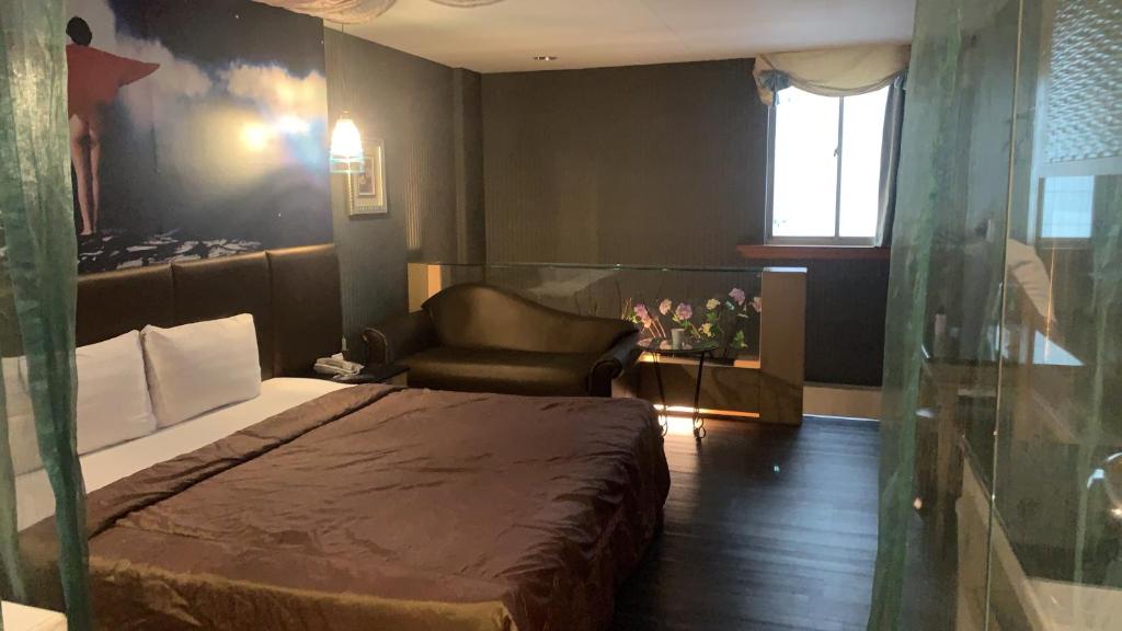 高雄亚历山大汽车旅馆 的卧室配有床、椅子和窗户。