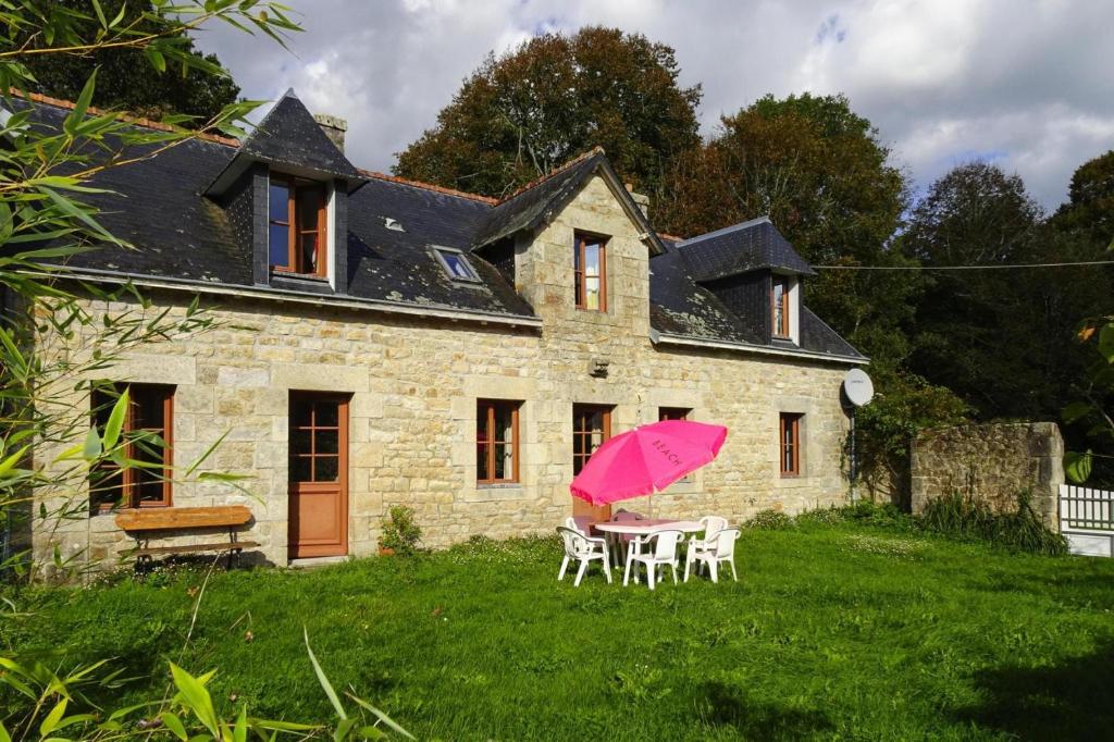 贝诺代Semi-detached house, Bénodet的一个带桌子和粉红色伞的房子