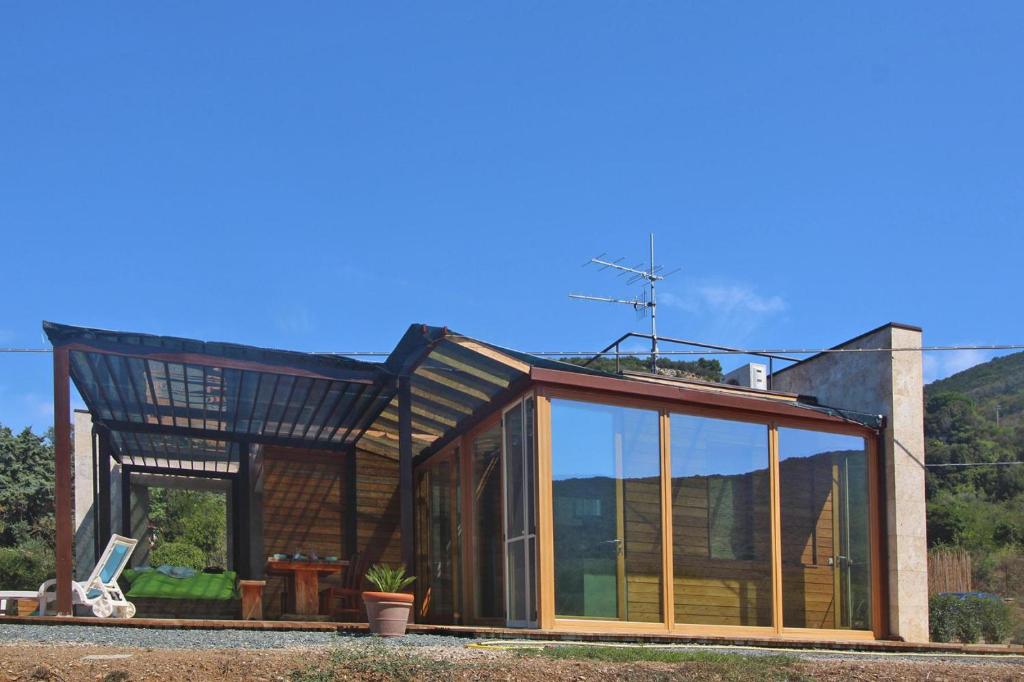 SantʼAnnaHoliday home Biocasa Fabiana, Portoferraio Magazzini的屋顶房屋的玻璃延伸