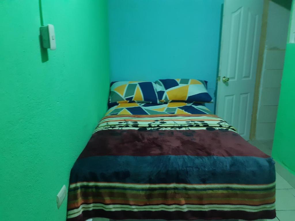危地马拉HOTEL EL EDEN的一间卧室配有一张带五颜六色棉被的床