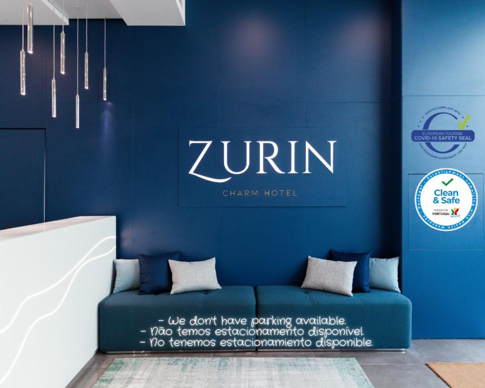 里斯本Zurin Charm Hotel的蓝色的墙壁和蓝色的沙发