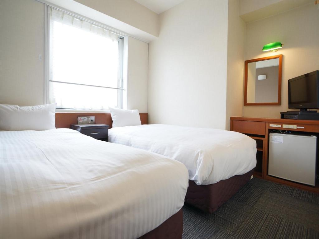 熊本银座通酒店的酒店客房设有两张床和电视。